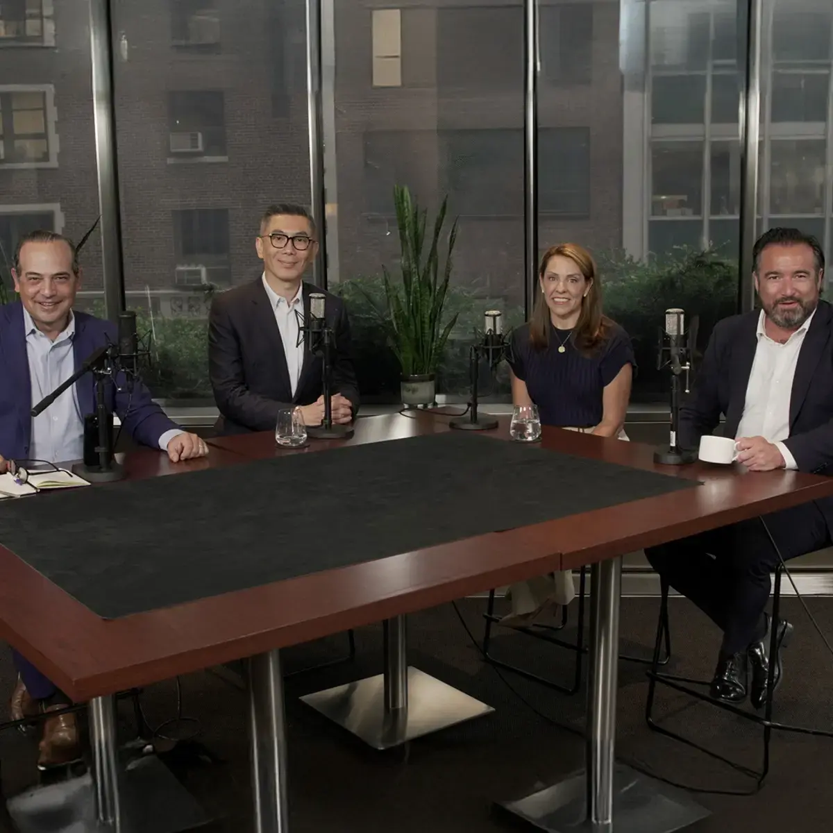 four-panelists-podcast-table-mics-hero